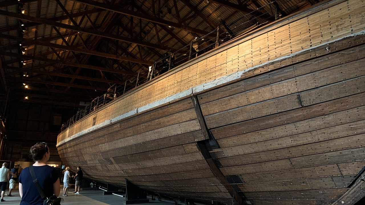 Phone photo of the wooden hull of Fram inside the museum hangar in Oslo
