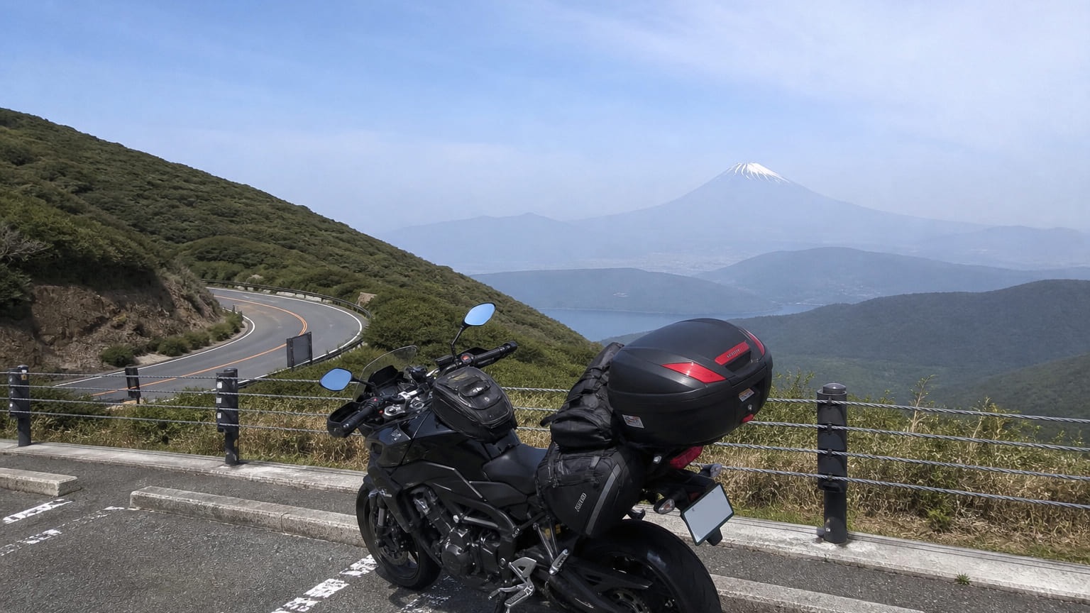 Motorcycle parked at a Hakone mountain overlook with Mount Fuji in the distance