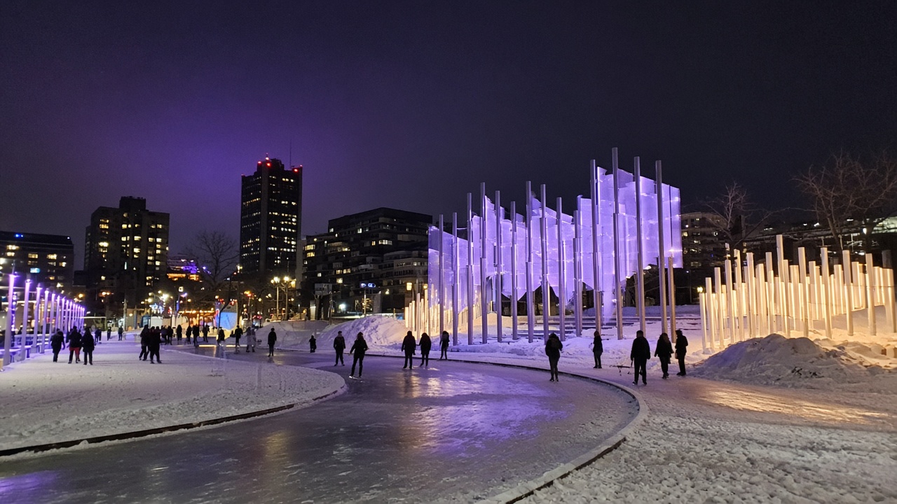 Casual smartphone photo of light installations and winter skating at Place des Festivals in Montréal