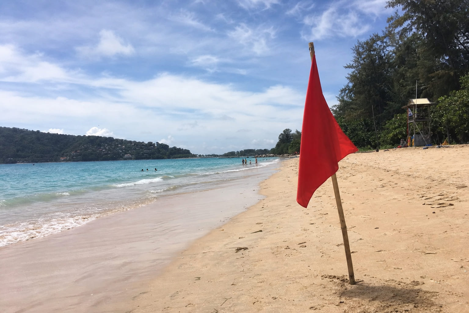 Red warning flag on a Thailand beach — dangerous swimming conditions, casual phone photo by a tourist