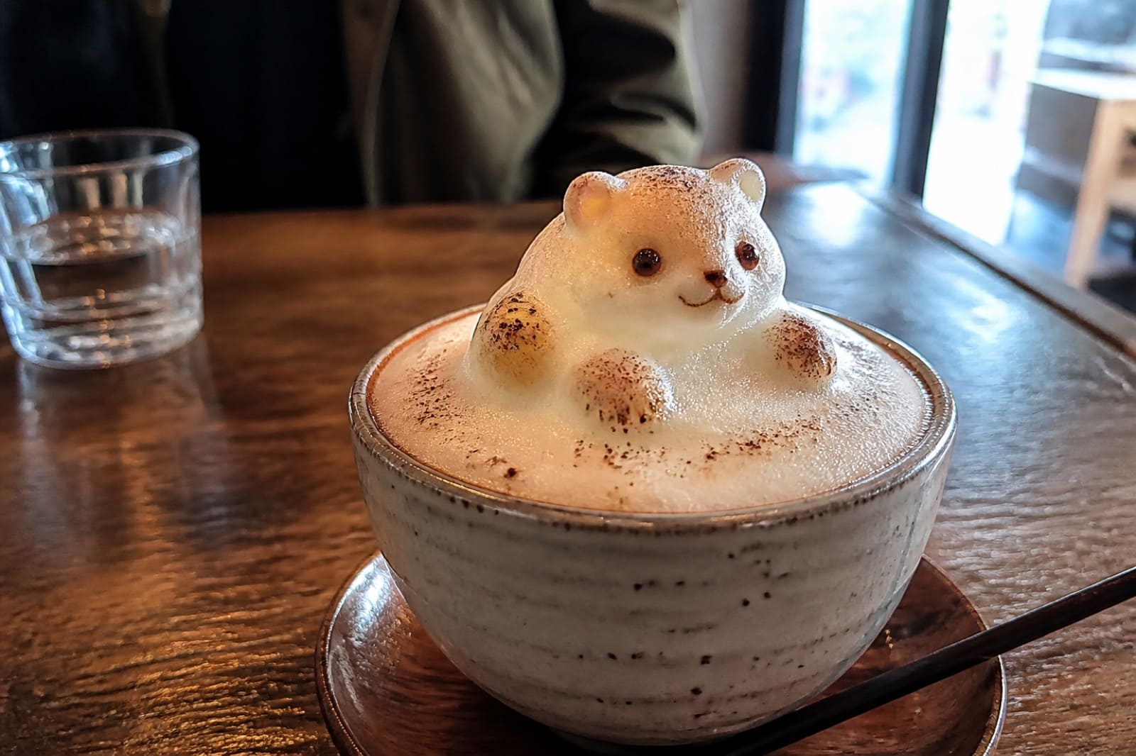 Cup with 3D latte art on a cafe table in Harajuku — tourist smartphone photo