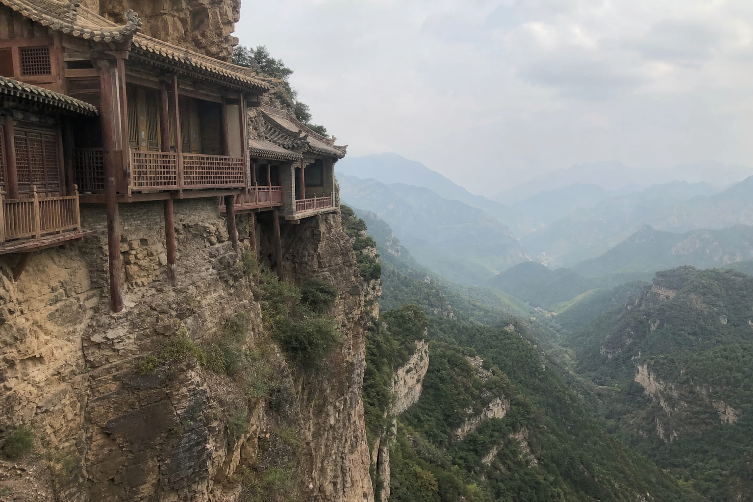 Smartphone photo of a cliffside temple in China among misty mountains