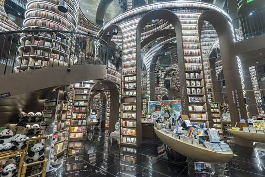 Interior of Zhongshuge bookstore in Dujiangyan with curved shelves and a mirrored ceiling — tourist phone photo