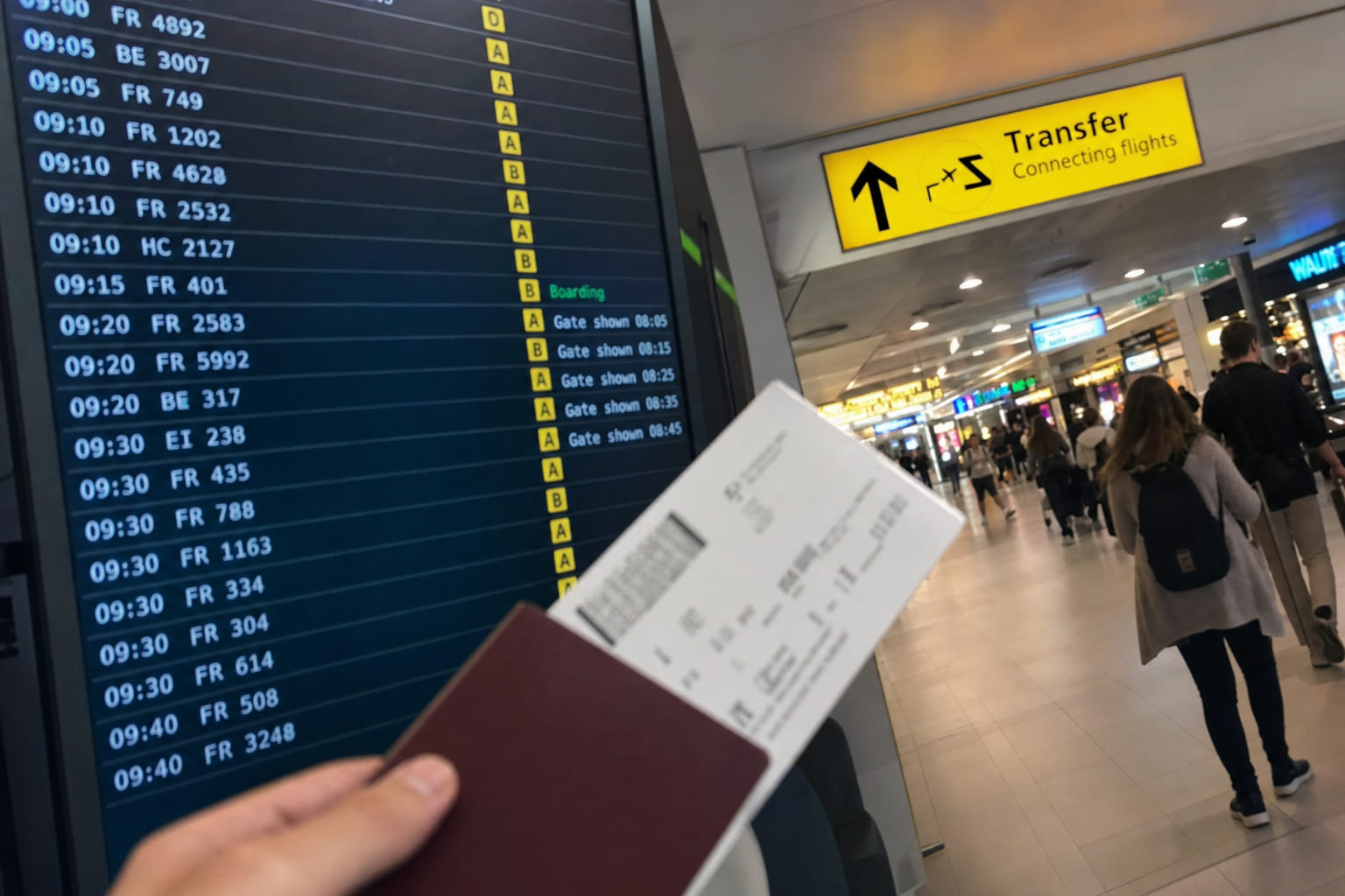 Phone snapshot at an airport: departure board, boarding pass in hand, Transfer sign in the corridor