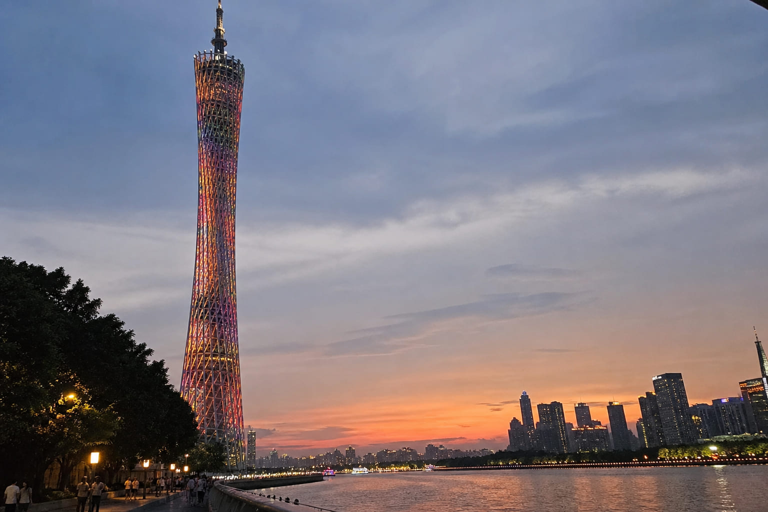 Canton Tower Guangzhou at dusk — tourist phone snapshot from the Pearl River promenade