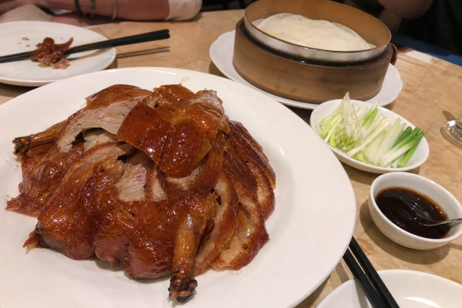 Tourist phone photo of Peking duck with pancakes and hoisin sauce at a Chinese restaurant